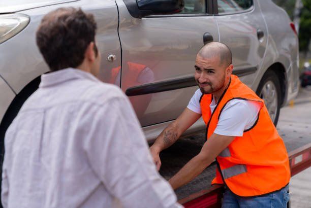 Recovery operator talking to a driver beside their car
