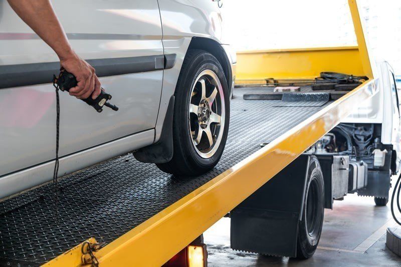 Securing a car to a recovery truck with straps